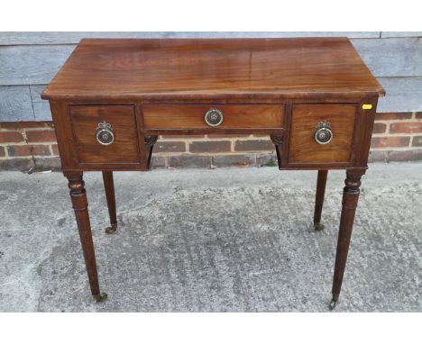 A William IV mahogany kneehole desk/dressing table, fitted two deep and one shallow drawer, on turned and castored supports, 