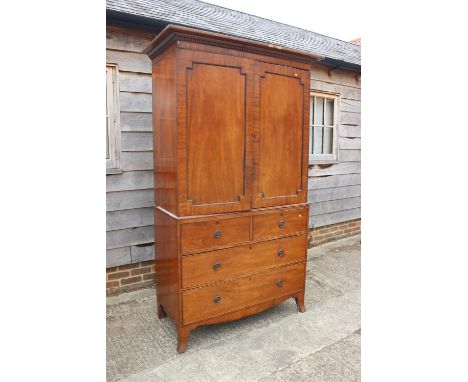 An early 19th century mahogany linen press, the upper section enclosed two doors, over two faux drawers and two long drawers,