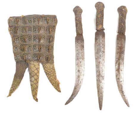 A 19th Century Sudanese Mahdist People triple knife dagger. Three daggers with etched blades housed within a Nile skin crocod