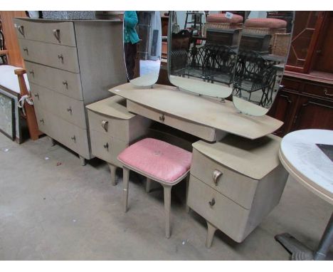 A retro dressing table with stool and matching chest of drawers