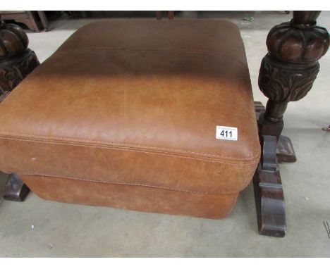 A large brown leather foot stool/pouffe