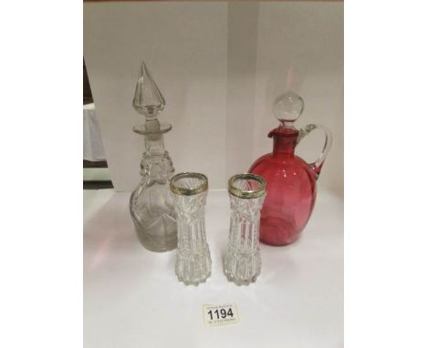 A cranberry glass jug, a glass decanter and 2 glass vases with a/f silver rims