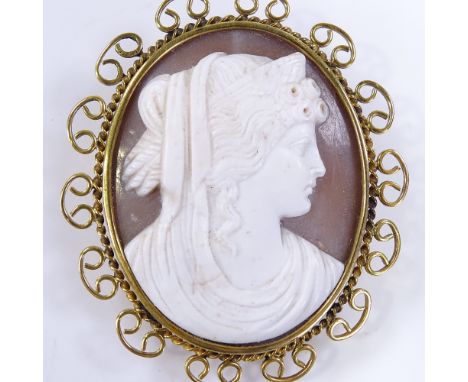 An oval relief carved cameo shell panel brooch, depicting Classical female portrait, in 9ct gold rope twist and openwork fram