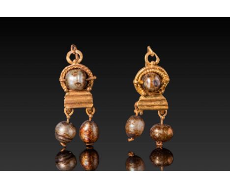 Ca. AD 1 - 300. A matched pair of gold earrings, each composed of a central spherical pearl bead held between two gold wire l