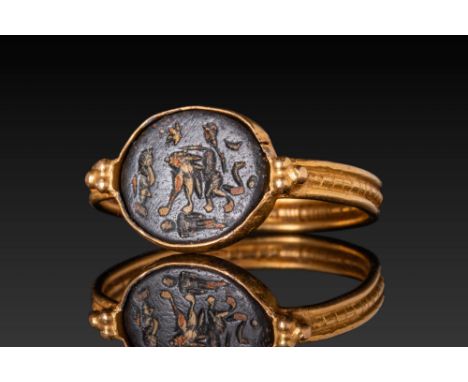 ca. 300 - 400 AD. An intaglio in dark stone engraved with Eros riding a lion to the right. The gem is set in an oval bezel wi