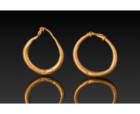 Ca. 300 - 100 BC. A pair of gold earrings, each formed from a hoop with rounded outer contours and tapering towards the termi