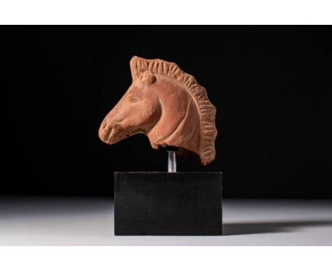 Ca. 400 - 300 BC. A terracotta fragment of a horse head with an arched neck and mane rendered with a row of vertical grooves.