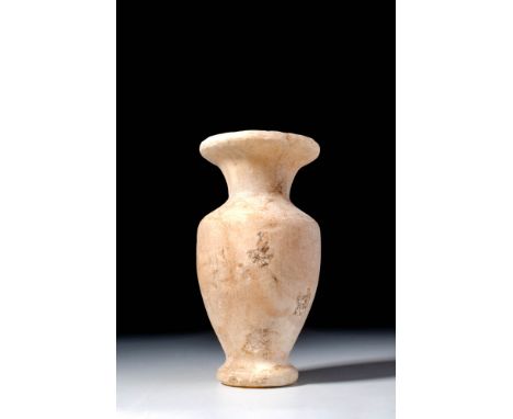 New Kingdom, Ca. 1550 - 1069 BC. A slender alabaster vessel with a disc-shaped base, inverted piriform body, and a short neck