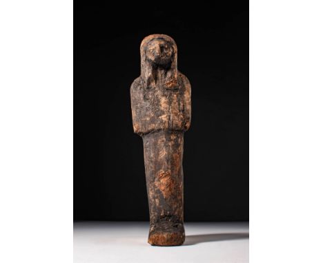 New Kingdom, Ca. 1550 - 1069 BC. A wooden ushabti figure depicted standing with hands placed on the chest and wearing a tripa