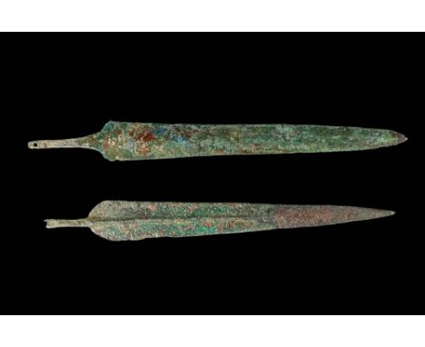 Ca. 1200 - 800 BC. A pair of cast bronze spearheads, each with elongated, tapering blade and narrow tang. One has flaring sho