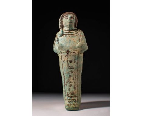 Third Intermadiate Period, Ca. 1069 - 664 BC.A blue-green glazed faience ushabti with arms crossed over the chest and wearing