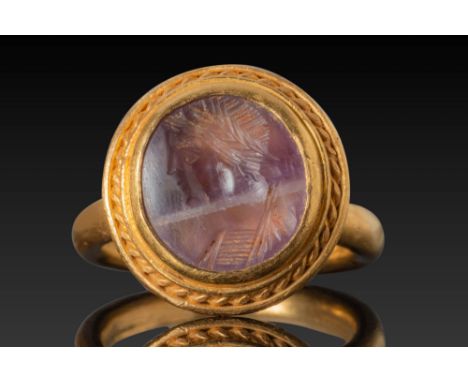 Ca. AD 70 - 600. An amethyst intaglio engraved with a left-facing male bust identified as Vitellius. He is depicted with a br