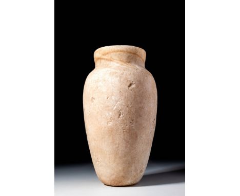 Old Kingdom, 4th to 6th Dynasty, 2613 BC to 2181 BC. An alabaster vessel with a tall body that narrows towards the flat base 