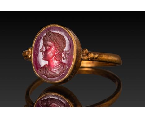 Ca. AD 100 - 200. A garnet intaglio engraved with the bust of a youthful male, possibly a young emperor. He is facing left, w