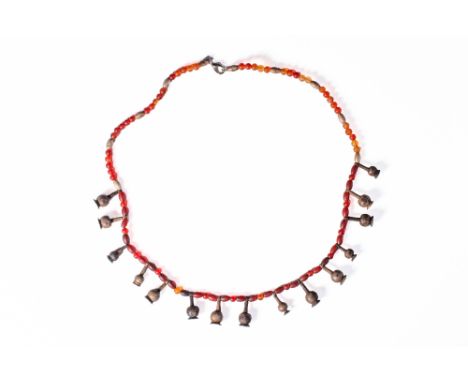 New Kingdom, Ca. 1550 - 1069 BC. A restrung strand made up of spherical carnelian beads regularly spaced with small silver ba