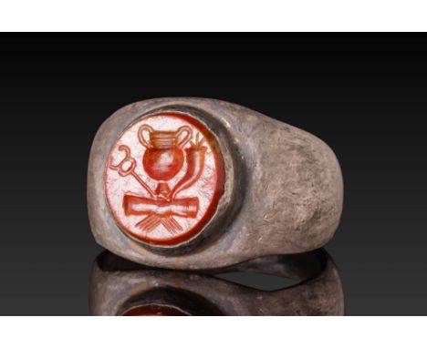 Ca. AD 1 - 100.A circular red jasper intaglio engraved with a pair of clasped hands beneath an amphora, caduceus, and cornuco