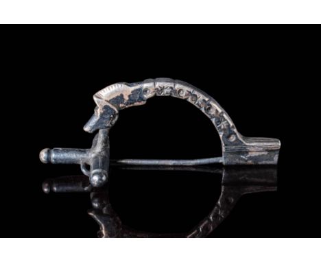 Ca. AD 100 - 300. A silver brooch with an arched bow decorated with alternating star and circle motifs along its length. The 
