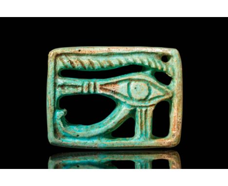 Late Period, Ca. 664 - 332 BC. A rectangular faience Wadjet amulet with an openwork design. The stylized eye features a centr