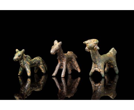 Ca. 800 BC.A group of three small bronze figurines representing stylised quadrupeds with simplified bodies and short, robust 