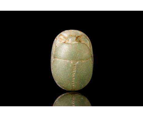 Ca. 500 - 300 BC. A chalcedony scarab with a segmented dorsal surface and incised legs. The underside with incised inscriptio