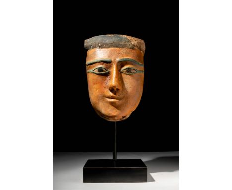 Late Period, Ca. 664 - 332 BC. A wooden mask from a sarcophagus with a smooth, oval-shaped face and defined features. The alm