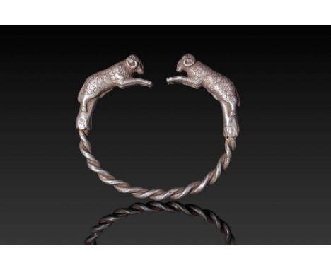 Ca. 500 BC. A penannular silver bracelet with a rounded shank, composed of two thick silver rods twisted together. Each end i