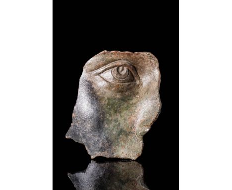 Ca. AD 1 - 300. A bronze fragment from a lifesize statue, preserving the right eye and part of the surrounding facial contour