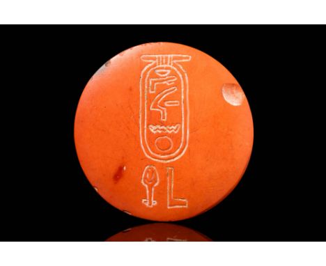 New Kingdom, Ca. 1550 - 1069 BC. A red stone stamp featuring a deeply incised cartouche with a hieroglyphic inscription. The 