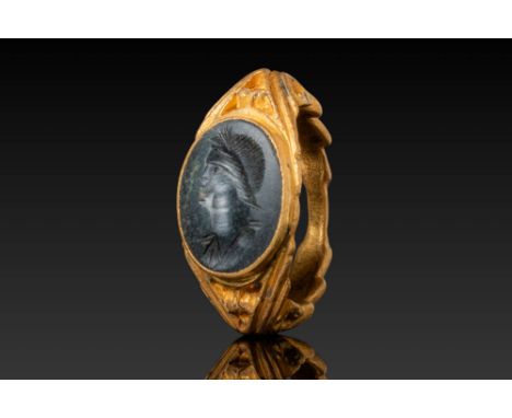 Ca. AD 1 - 200. A dark stone intaglio engraved with a left-facing female bust. Her hair is neatly arranged in parallel rows d