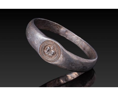 Ca. AD 1 - 300. A silver bracelet with a central, slightly recessed medallion bordered by a beaded frame and decorated with a