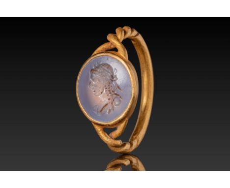 Ca. AD 200 - 300. A chalcedony intaglio engraved with a left-facing bust of Apollo. The youthful face is shown with large eye