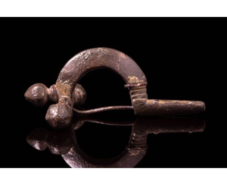 Ca. AD 300 - 400.A bronze-gilt crossbow brooch with a pin and solid arched bow. The crossbar terminates in three prominent fa
