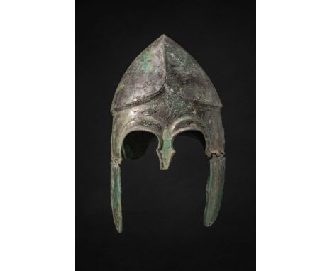 Ca. 500 BC. A bronze Chalcidian helmet with a rounded skull and a high carinated crown. A raised ridge runs along the lower e