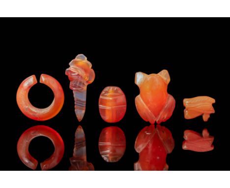 Middle Kingdom to New Kingdom, Ca. 2055 - 1069 BC. A collection of five carnelian amulets, including a crescent-shaped hair r
