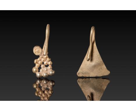 Ca. AD 1 - 300. A pair of gold earrings. The one on the left is composed of openwork clustered pellets in graduated rows, wit