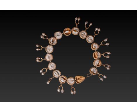 Ca. AD 100 - 250. A necklace formed of a series of 17 gold settings containing inset white glass elements with central ridges