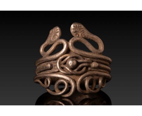 Ca. 100 BC - AD 100. A silver ring formed from multiple parallel wires, creating a wide band with two opposing snake heads ex