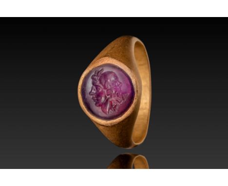 Ca. AD 1 - 200. A round amethyst intaglio depicting a gryllos motif, featuring two conjoined heads facing opposite directions