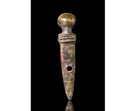 Ca. AD 1 - 300.A bronze amulet in the form of a legionary gladius sword. The blade tapers to a point and is pierced at its mi