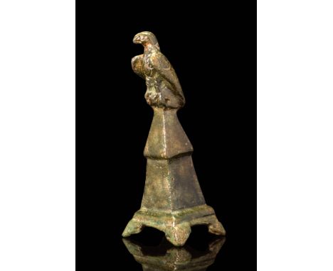 Ca. AD 200.A bronze eagle perched atop a tapering, stepped podium with quadripartite base. The bird is rendered with a rounde