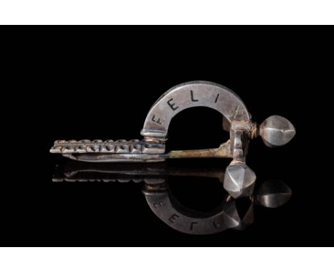 Ca. AD 100 - 200. A crossbow brooch with a pin and solid arched bow engraved with the Latin inscription VTERE FELIX, meaning 