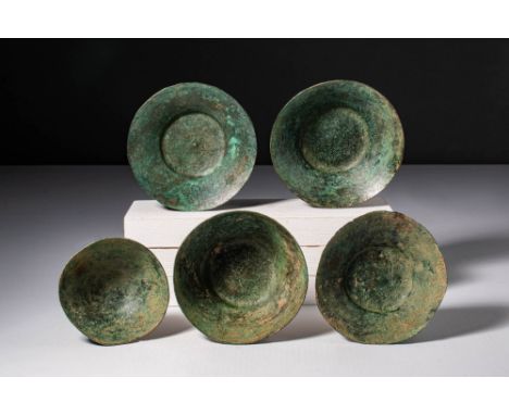 Ca. 400 - 200 BC. A collection of five hammered bronze bowls, displaying a range of profiles including flaring forms with fla