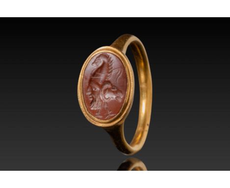 Ca. AD 100 - 300. A red jasper intaglio engraved with a Gryllos motif, combining a bearded mask in left profile, an equine pr