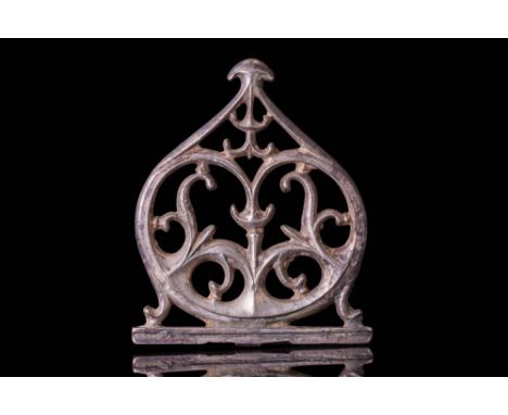 Ca. AD 100 - 300. An openwork silver appliqué with a pointed arched outline and symmetrical scrolling branches rising from th
