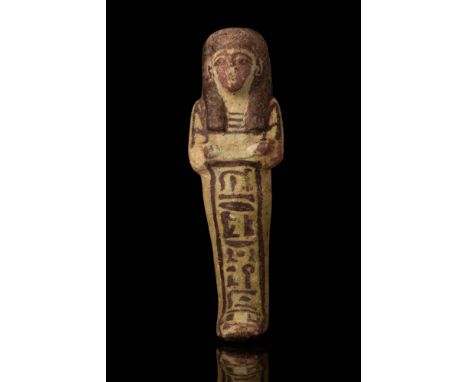 19th Dynasty, Ca. 1292 - 1189 BC.A faience ushabti with a mummiform body, crossed arms, and a column of hieroglyphic inscript