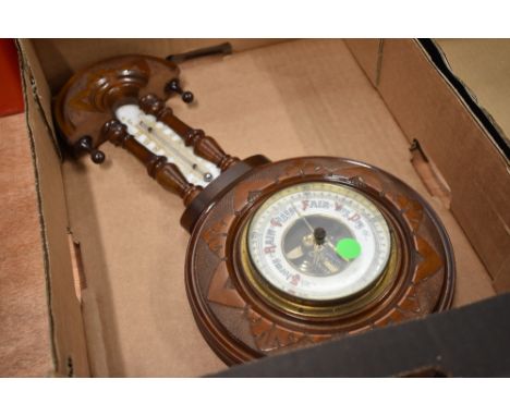 An Edwardian stipple carved barometer with enamelled dial and thermometer scale