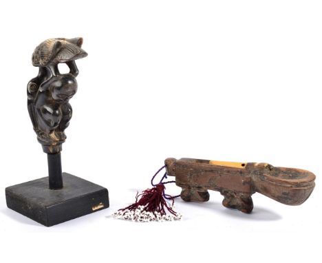 A Lombok Buffalo Horn Kris Handle, carved as a stork perched on the back of a crouching man, loosely mounted on a contemporar