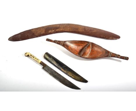 An Australian Aboriginal Boomerang, one side carved with an Emu on a roughened field, 51cm; a South Sea Islands Boat Shaped D