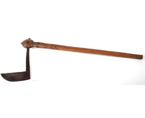 A Senufo War Axe, West Africa, with hand forged angular upswept blade, the tang inserted into the wood disc shape head on a c
