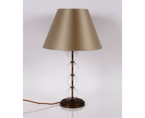 A modern design glass and brass table lamp, having globular column and cream shade, 60cm high 